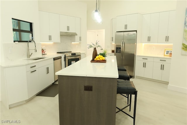 kitchen featuring sink, tasteful backsplash, a center island, and stainless steel appliances