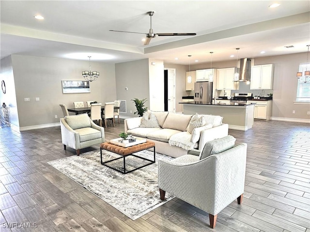 living room featuring ceiling fan with notable chandelier