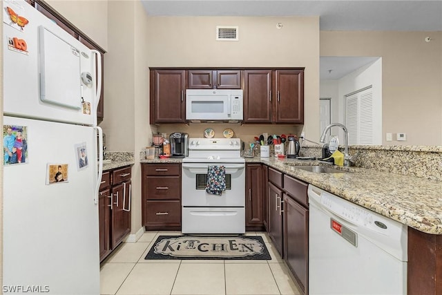 kitchen featuring light stone countertops, light tile patterned floors, sink, and white appliances