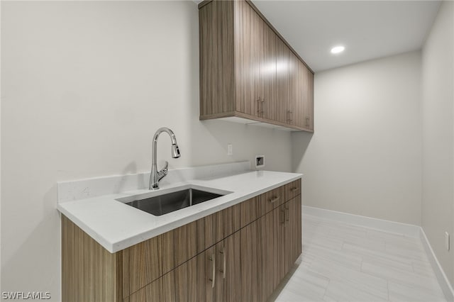 washroom featuring sink, hookup for a washing machine, and cabinets