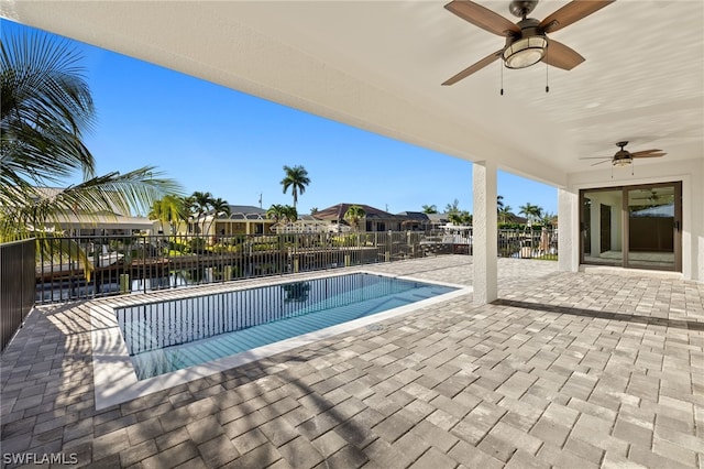 view of swimming pool featuring a patio area, ceiling fan, and a water view