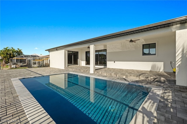 back of house featuring ceiling fan, a fenced in pool, and a patio