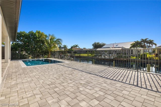 view of swimming pool featuring a patio and a water view