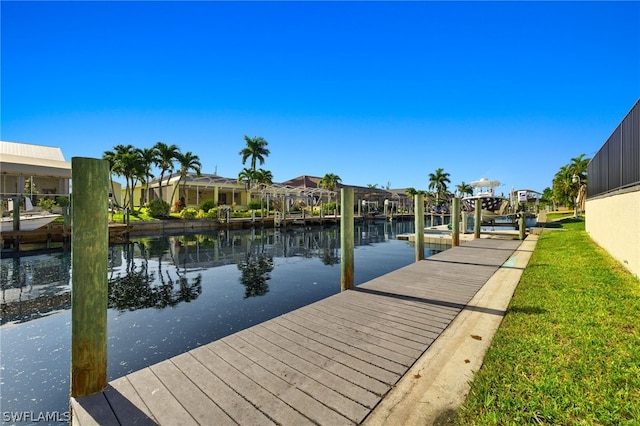 view of dock with a water view and a lawn