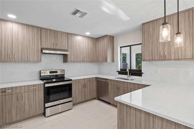 kitchen featuring pendant lighting, sink, decorative backsplash, and stainless steel appliances