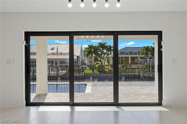 doorway to outside with light tile patterned flooring