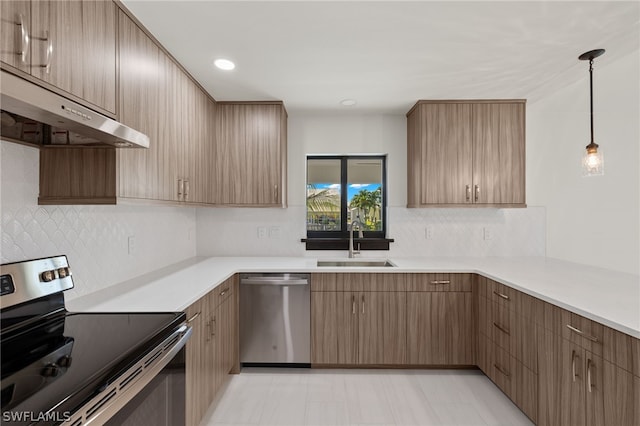 kitchen with pendant lighting, sink, decorative backsplash, and stainless steel appliances