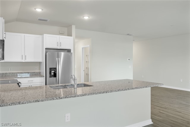 kitchen featuring stainless steel refrigerator with ice dispenser, sink, white cabinetry, and light stone counters