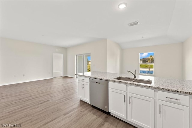 kitchen featuring stainless steel dishwasher, sink, light stone counters, and white cabinetry