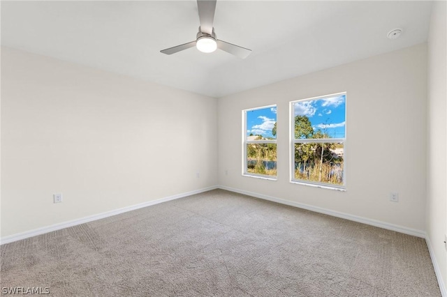 carpeted spare room featuring ceiling fan