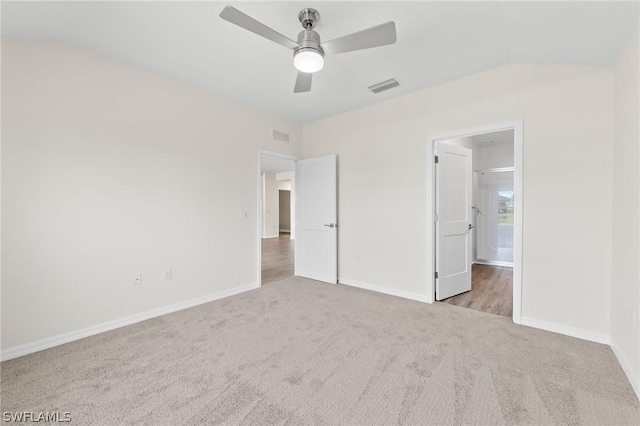 unfurnished bedroom with ceiling fan, light carpet, and vaulted ceiling