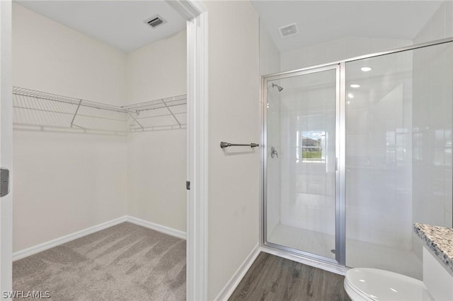 bathroom with toilet and a shower with shower door