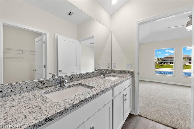 bathroom with ceiling fan, wood-type flooring, vanity, and lofted ceiling