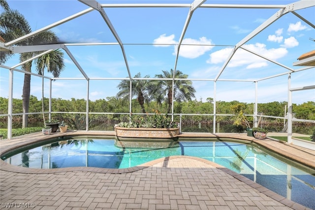 view of swimming pool featuring a patio area and glass enclosure