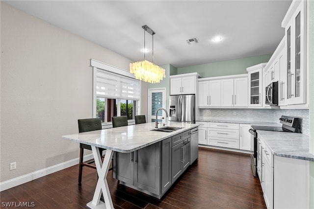 kitchen featuring appliances with stainless steel finishes, dark hardwood / wood-style flooring, white cabinetry, and decorative backsplash