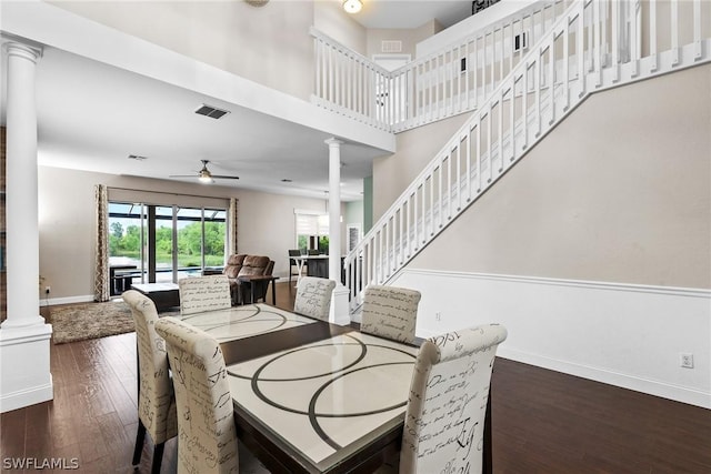 dining area featuring ornate columns, a high ceiling, dark hardwood / wood-style floors, and ceiling fan