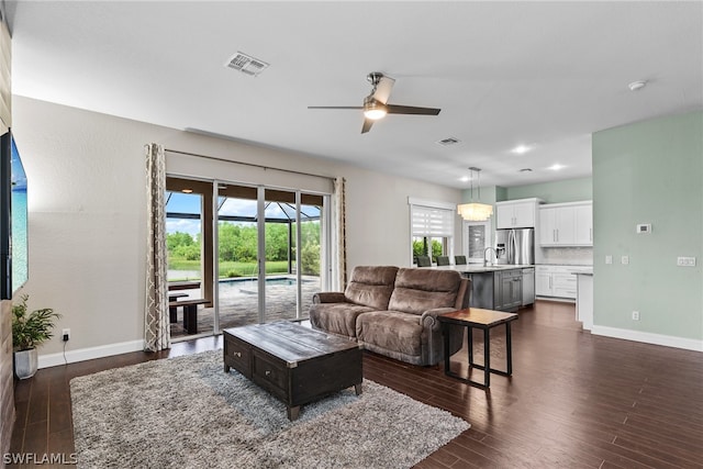 living room with ceiling fan, sink, and dark hardwood / wood-style flooring