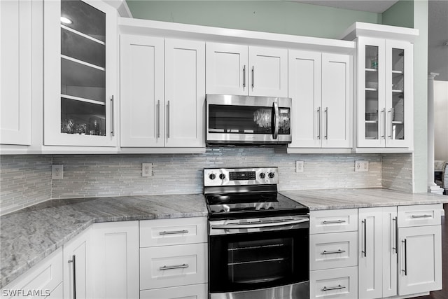 kitchen featuring appliances with stainless steel finishes, white cabinets, and backsplash