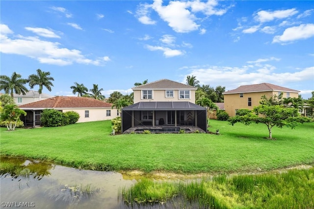 back of property featuring a water view, a yard, and glass enclosure