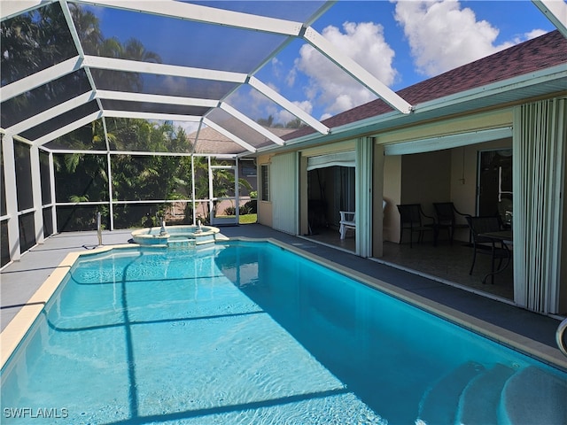 view of swimming pool with glass enclosure, an in ground hot tub, and a patio area