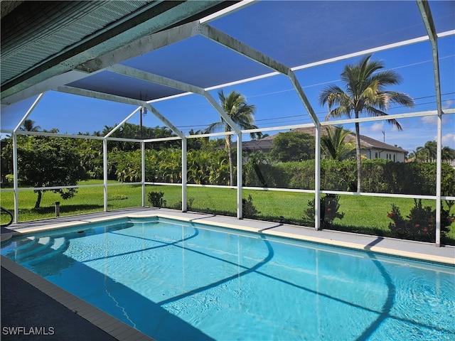 view of pool featuring a lawn and a lanai