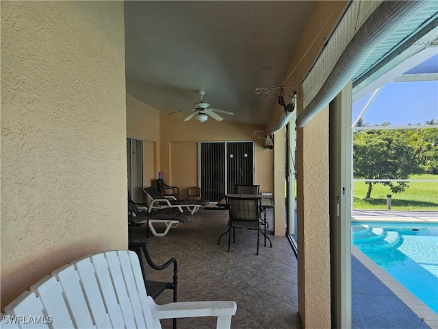 view of patio featuring ceiling fan and a lanai