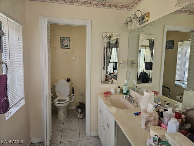 bathroom featuring vanity, tile patterned flooring, toilet, and a wealth of natural light