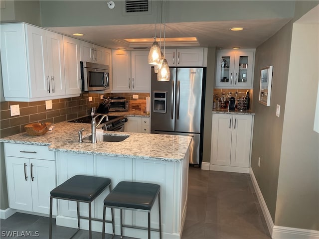 kitchen with decorative backsplash, appliances with stainless steel finishes, and white cabinets