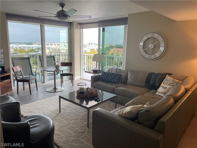 tiled living room with expansive windows and ceiling fan