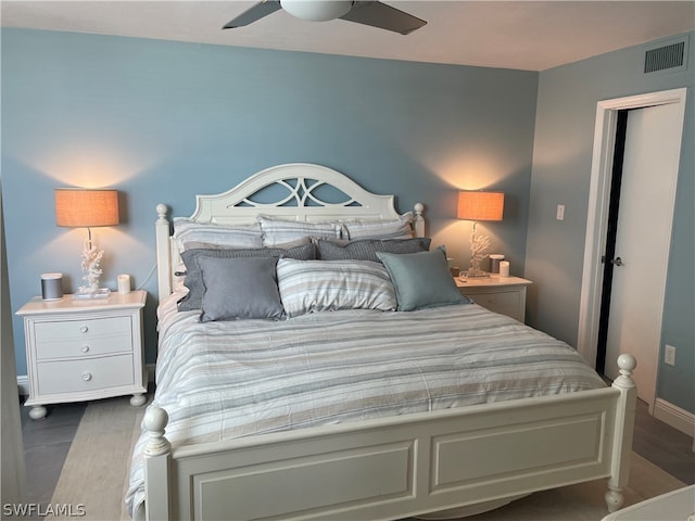 bedroom with dark hardwood / wood-style flooring and ceiling fan