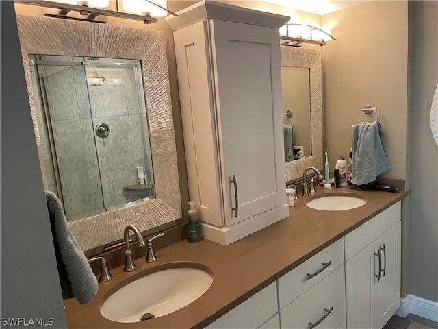 bathroom featuring a tile shower and double sink vanity