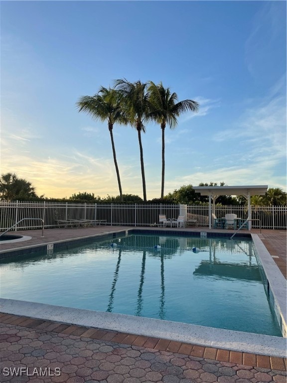 pool at dusk featuring a patio area