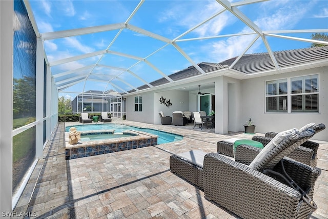 view of pool featuring an in ground hot tub, ceiling fan, a patio area, and a lanai