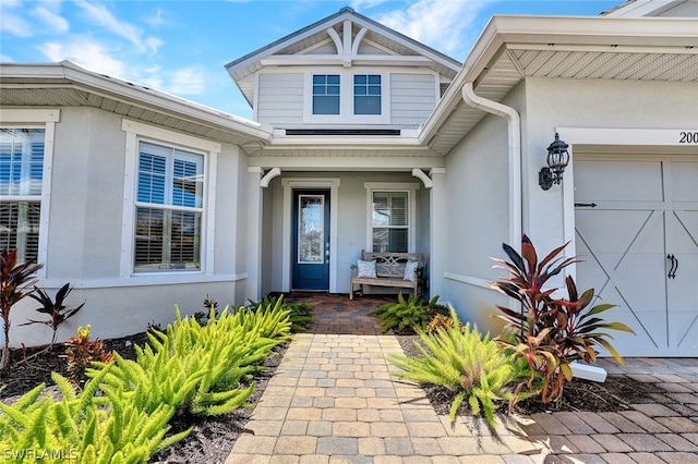 20012 Tavernier Dr, Estero, FL 33928 - doorway to property with stucco siding, covered porch, and a garage