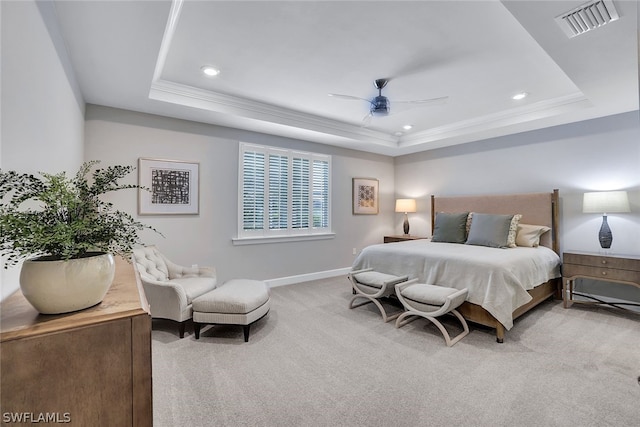 carpeted bedroom with a raised ceiling and ceiling fan