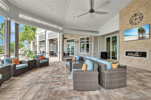 sunroom with lofted ceiling, french doors, wood ceiling, ceiling fan, and a fireplace