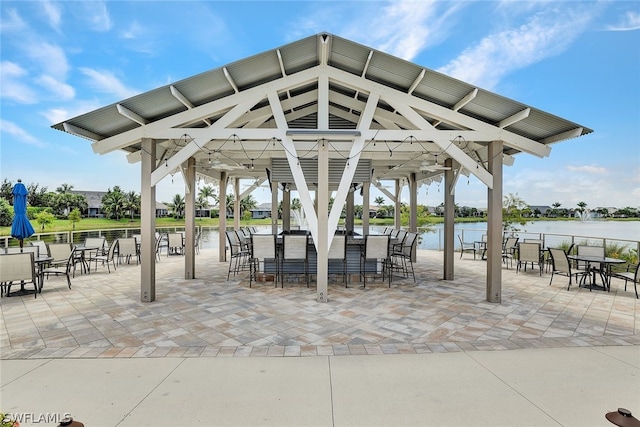 view of community featuring a water view, a gazebo, and a patio area