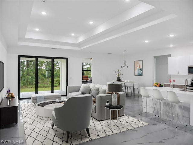 living room featuring sink and a tray ceiling