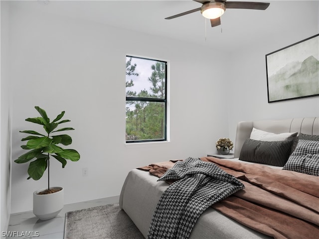 tiled bedroom featuring ceiling fan