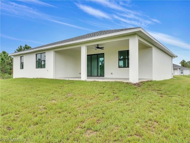 rear view of house with a patio area, a yard, and ceiling fan