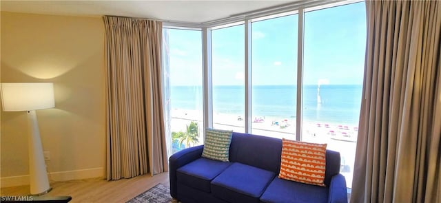 living room featuring hardwood / wood-style floors, a water view, and a beach view