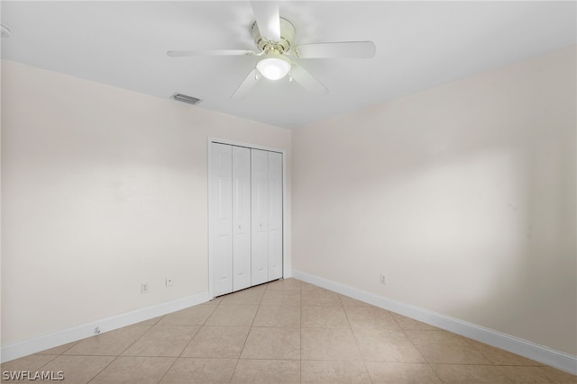 unfurnished bedroom featuring a closet, light tile patterned floors, and ceiling fan