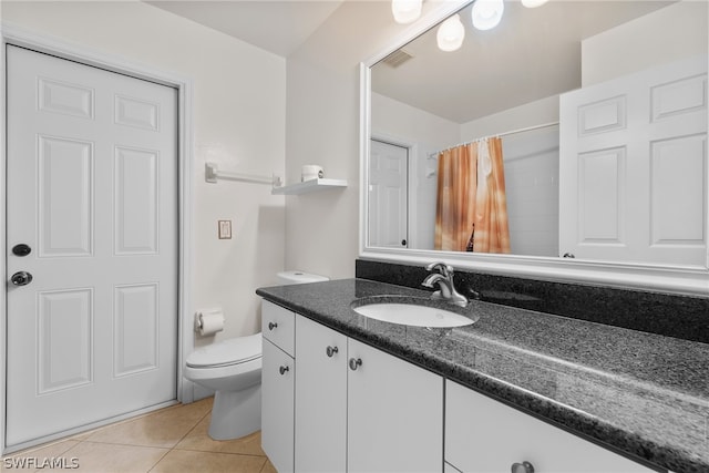 bathroom featuring vanity, toilet, and tile patterned floors