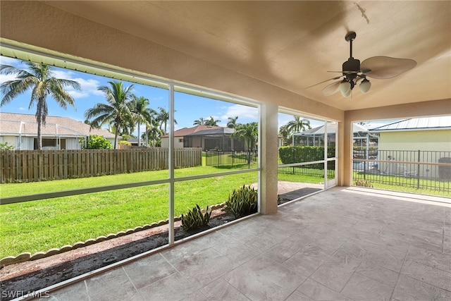 unfurnished sunroom featuring ceiling fan