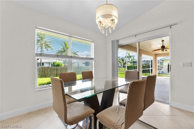 dining area with light tile patterned flooring and ceiling fan with notable chandelier