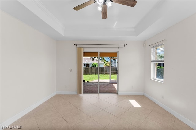 unfurnished room featuring ceiling fan, light tile patterned floors, and a tray ceiling