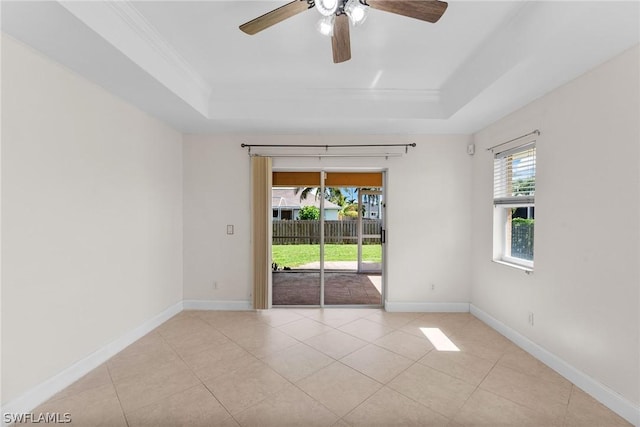 empty room with light tile patterned floors, crown molding, a raised ceiling, and ceiling fan