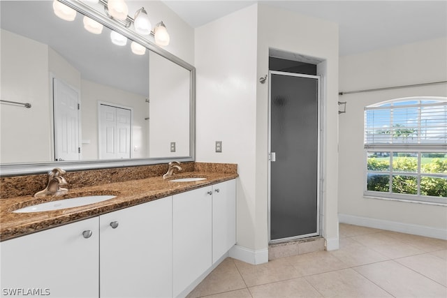 bathroom with a shower with shower door, tile patterned flooring, and double vanity