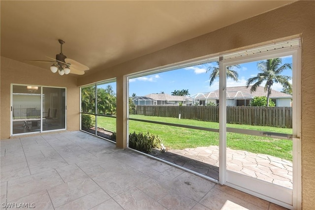 unfurnished sunroom featuring ceiling fan