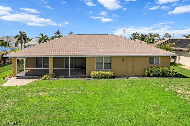 rear view of property featuring a sunroom and a yard